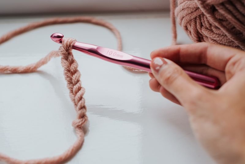 Hand crocheting with a pink hook